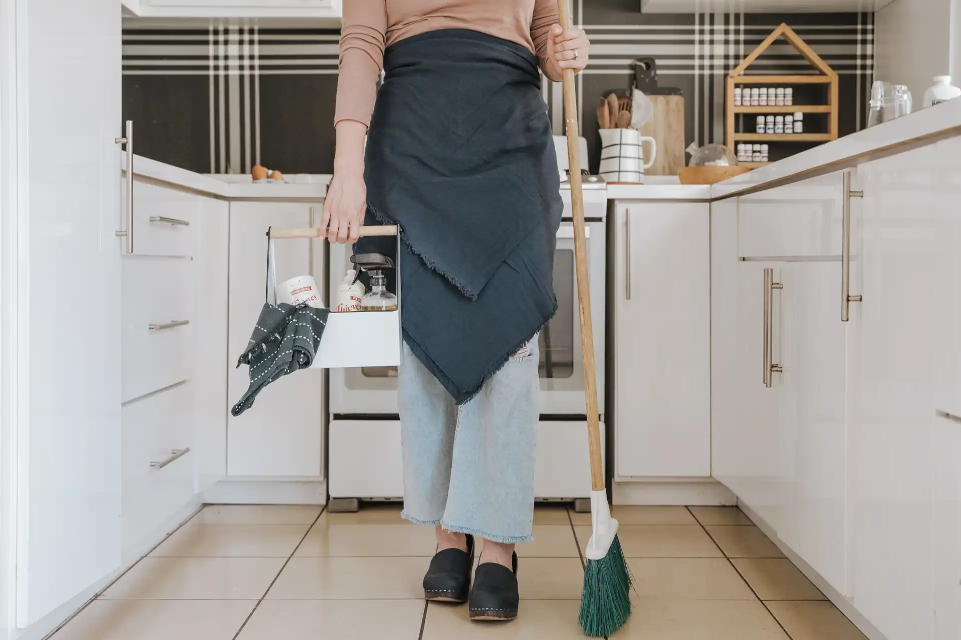 woman in kitchen with cleaning supplies