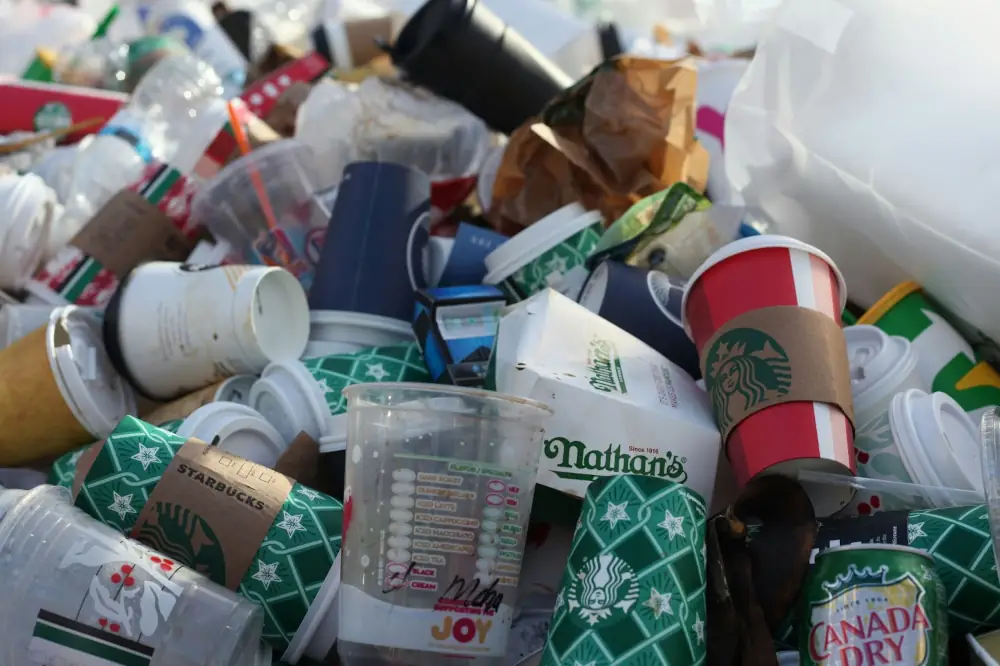 A Closeup of Trash containing lots of coffee cups and fast food containers
